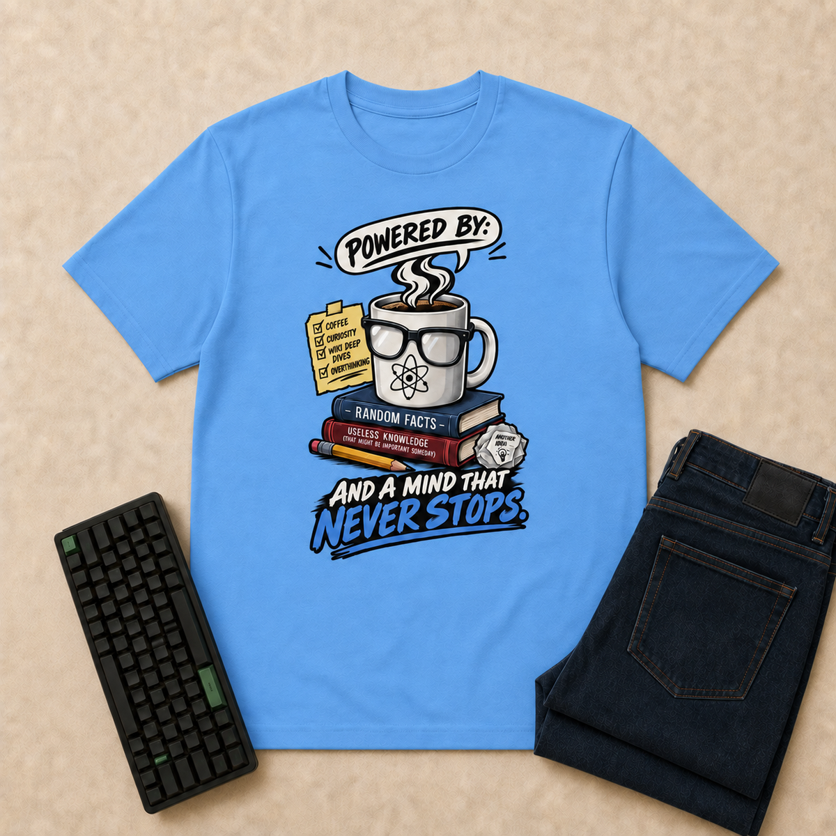 Powered By Nerd Life T-Shirt — Carolina Blue flat-lay with keyboard and double-folded indigo jeans