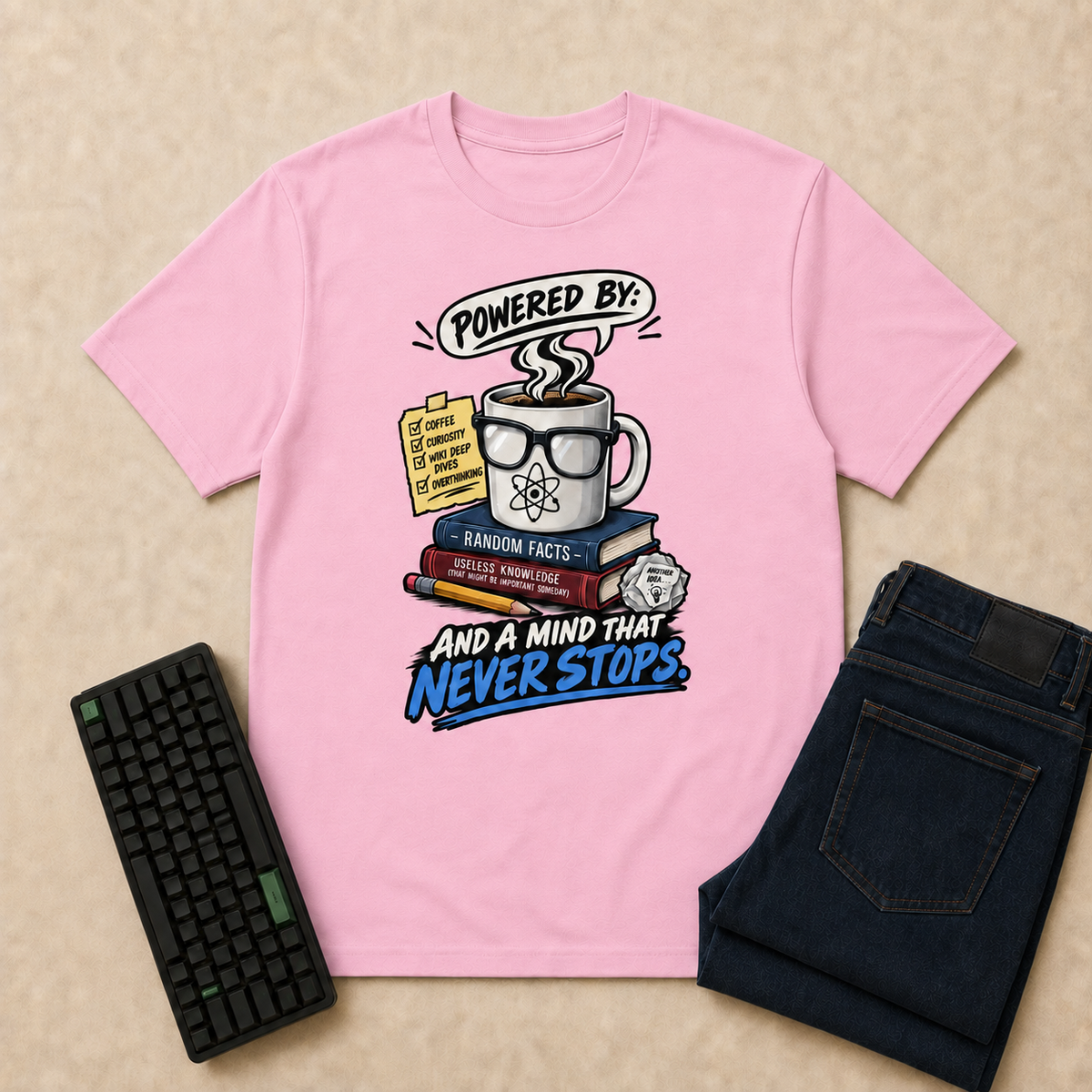 Powered By Nerd Life T-Shirt — Light Pink flat-lay with keyboard and double-folded indigo jeans