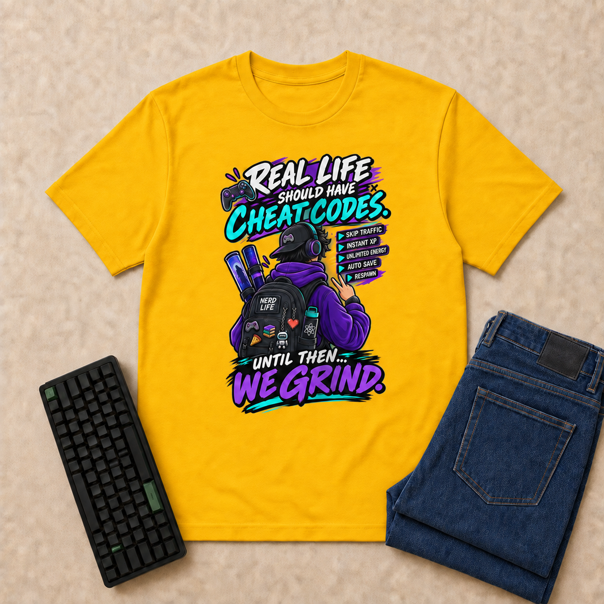 Real Life Nerd Life T-Shirt — Gold overhead flat-lay with keyboard and double-folded jeans